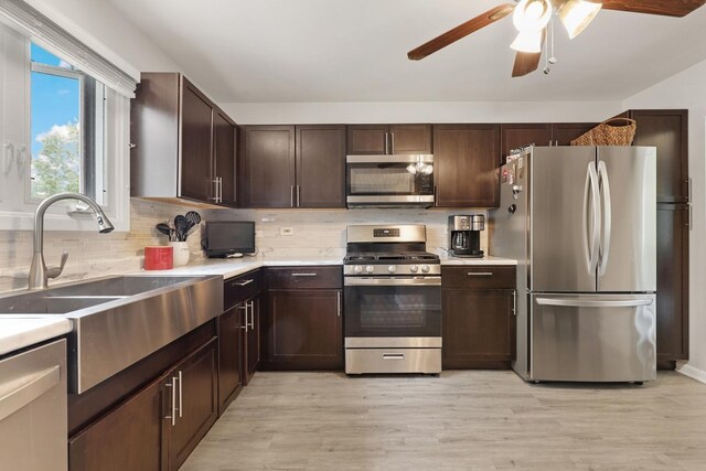 228 Oriole Rd, Matteson, IL 60443 - kitchen with stainless steel appliances, a sink, dark brown cabinets, ceiling fan, and backsplash