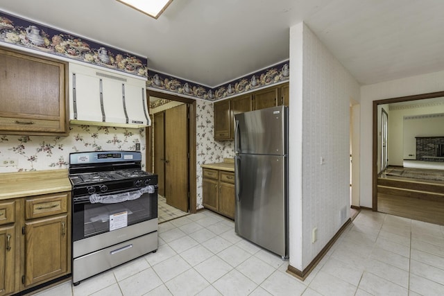 12375 W Ash Ct, Beach Park, IL 60099 - kitchen with appliances with stainless steel finishes, wallpapered walls, light countertops, light tile patterned floors, and brown cabinets