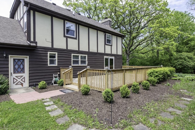 12375 W Ash Ct, Beach Park, IL 60099 - back of property with a chimney, a deck, roof with shingles, board and batten siding, and stucco siding