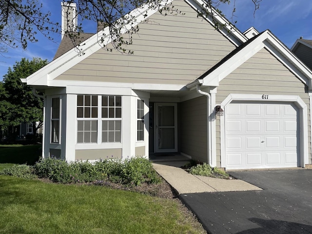 611 Kingsbridge Dr, Carol Stream, IL 60188 - view of front facade with a chimney, an attached garage, and driveway