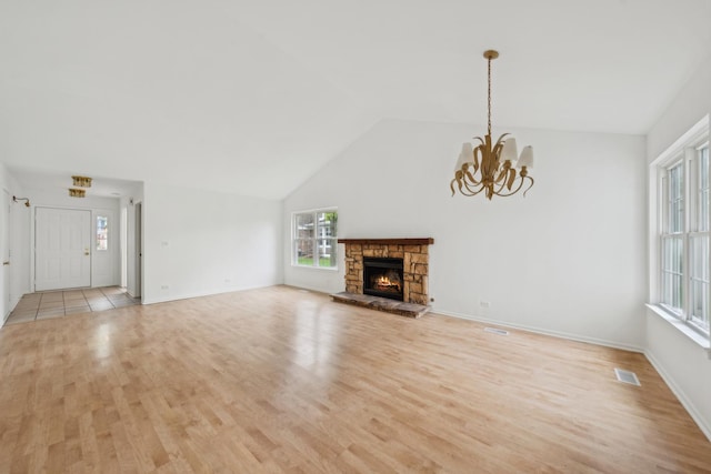 611 Kingsbridge Dr, Carol Stream, IL 60188 - unfurnished living room featuring light wood finished floors, a chandelier, a fireplace, baseboards, and high vaulted ceiling