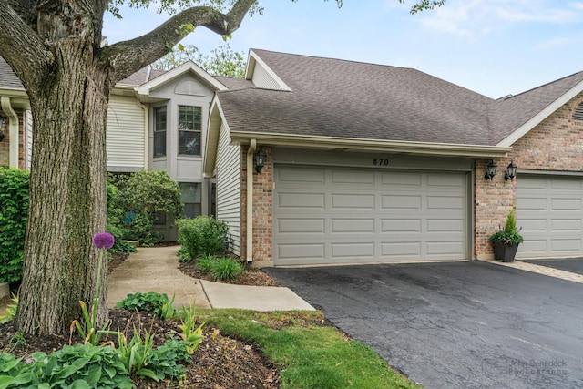 870 N Auburn Woods Dr, Palatine, IL 60067 - view of front of house featuring brick siding, a garage, driveway, and roof with shingles