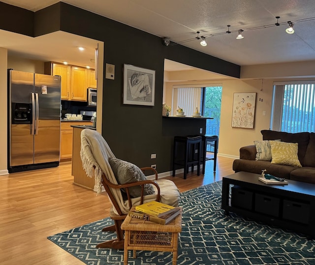 828 Graceland Ave Unit 404, Des Plaines, IL 60016 - living room with light wood-style floors, baseboards, and rail lighting