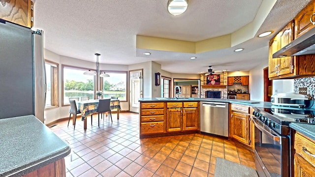 2903 Prairie Meadow Dr, Champaign, IL 61822 - kitchen with appliances with stainless steel finishes, a sink, brown cabinets, extractor fan, and dark countertops