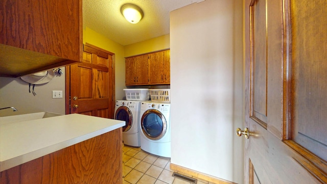 2903 Prairie Meadow Dr, Champaign, IL 61822 - washroom featuring cabinet space, washer and clothes dryer, light tile patterned floors, and a textured ceiling