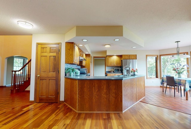 2903 Prairie Meadow Dr, Champaign, IL 61822 - kitchen with brown cabinets, stainless steel appliances, plenty of natural light, arched walkways, and a textured ceiling