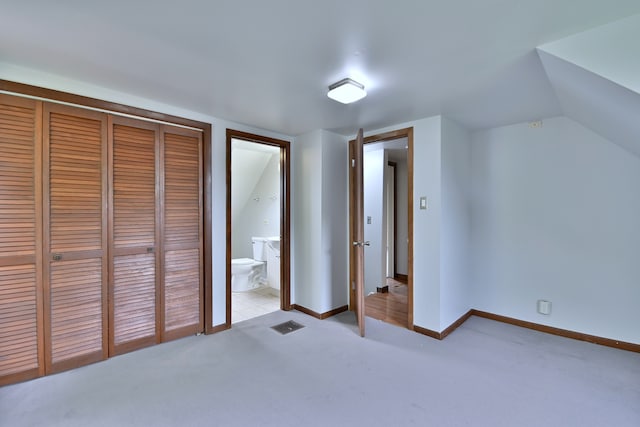 1021 Vine St, Joliet, IL 60435 - unfurnished bedroom with a closet, light carpet, baseboards, and ensuite bathroom