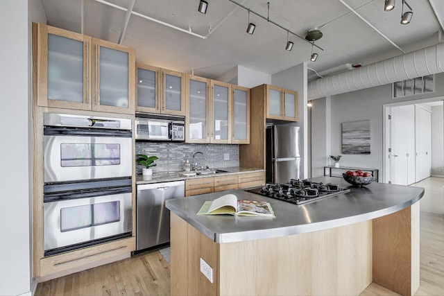 1530 S State St Unit 17B, Chicago, IL 60605 - kitchen featuring appliances with stainless steel finishes, a sink, a center island, light wood finished floors, and decorative backsplash