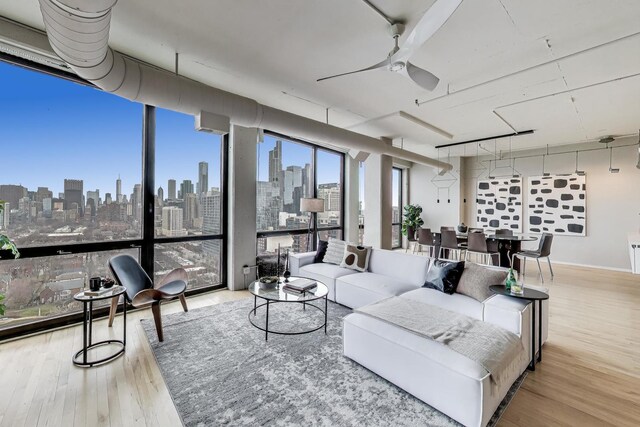 1530 S State St Unit 17B, Chicago, IL 60605 - living room with a view of skyline, wood finished floors, a ceiling fan, and a wall of windows