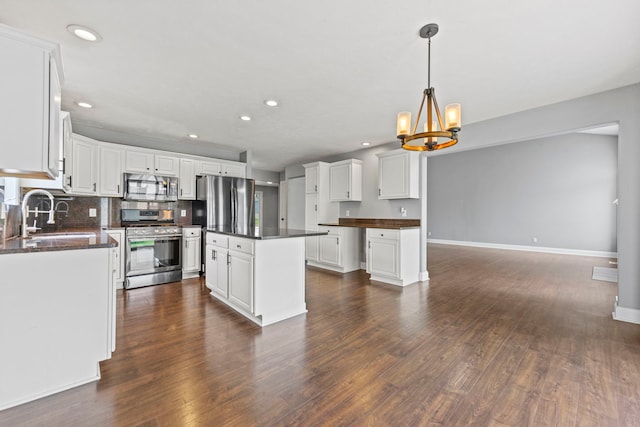 1924 Prestwold Pl, Machesney Park, IL 61115 - kitchen with stainless steel appliances, a sink, dark countertops, a chandelier, and dark wood finished floors