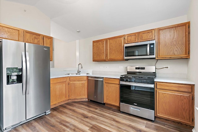 1623 Camberley Ct, Bartlett, IL 60103 - kitchen with appliances with stainless steel finishes, a sink, vaulted ceiling, light countertops, and dark wood-style flooring