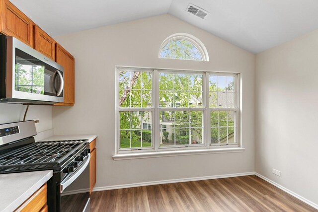 1623 Camberley Ct, Bartlett, IL 60103 - kitchen featuring stainless steel appliances, brown cabinets, light countertops, dark wood-style flooring, and vaulted ceiling