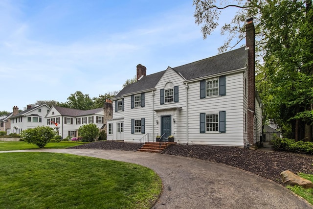 2906 Lincoln St, Evanston, IL 60201 - colonial home with a chimney, a front yard, and curved driveway