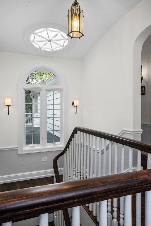 2906 Lincoln St, Evanston, IL 60201 - stairway featuring arched walkways, baseboards, and wood finished floors