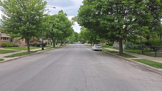 316 E 107th St, Chicago, IL 60628 - view of asphalt street featuring sidewalks, street lights, and curbs