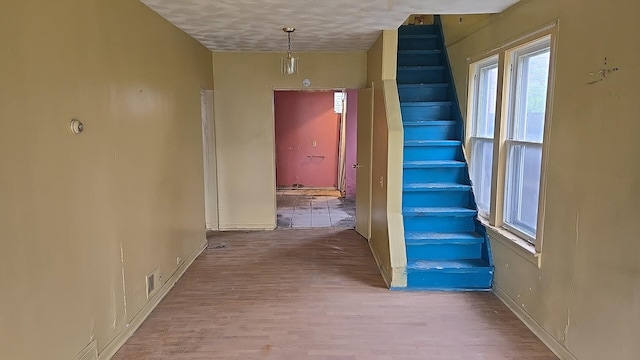 316 E 107th St, Chicago, IL 60628 - hallway with stairway, wood finished floors, baseboards, and a textured ceiling