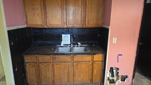 316 E 107th St, Chicago, IL 60628 - kitchen featuring dark countertops, backsplash, and brown cabinets