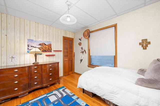 6141 W Peterson Ave, Chicago, IL 60646 - bedroom featuring a paneled ceiling, light wood finished floors, wood walls, and baseboards