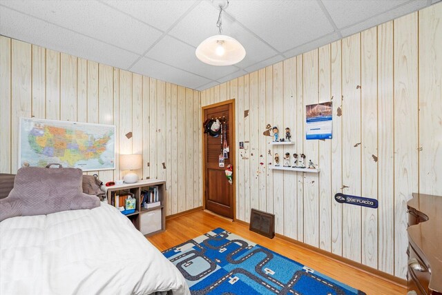 6141 W Peterson Ave, Chicago, IL 60646 - bedroom featuring a drop ceiling, wood finished floors, baseboards, and wooden walls
