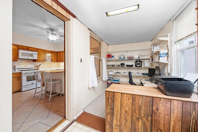 6141 W Peterson Ave, Chicago, IL 60646 - kitchen with white appliances, light countertops, brown cabinets, a ceiling fan, and light tile patterned flooring