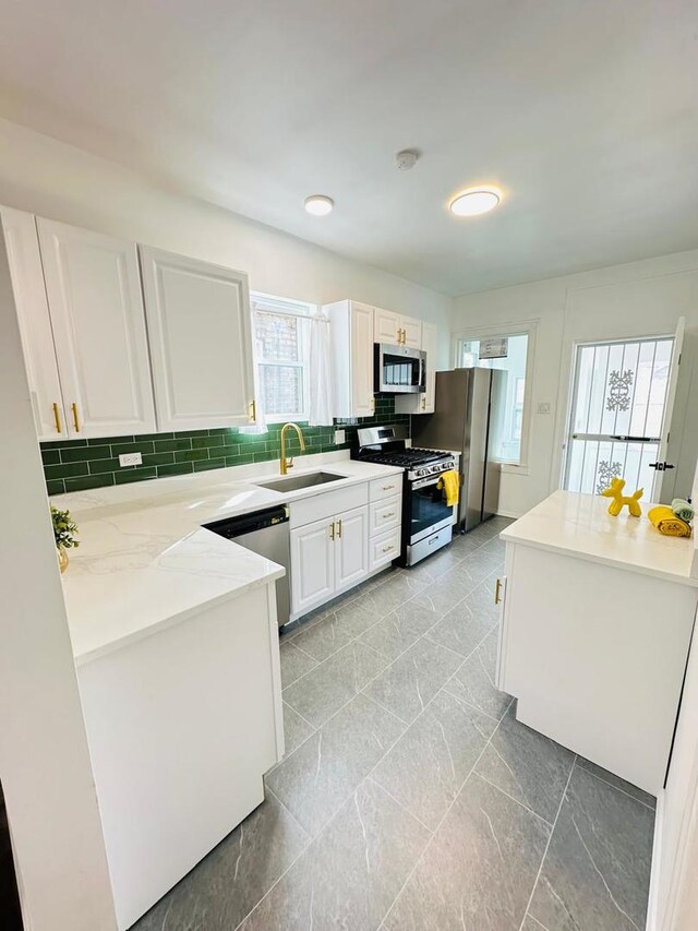 8344 S Ada St, Chicago, IL 60620 - kitchen with appliances with stainless steel finishes, a sink, white cabinetry, decorative backsplash, and light stone counters