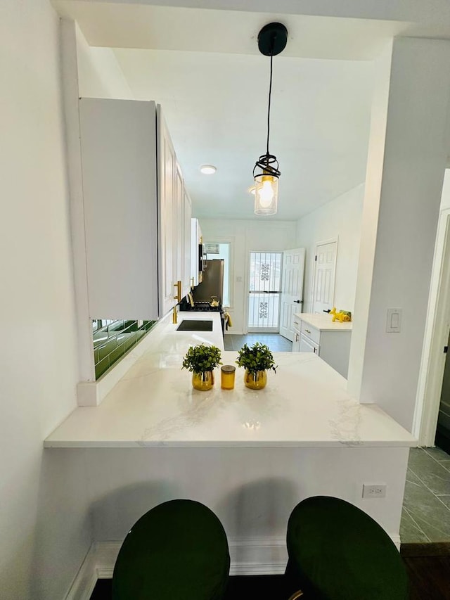 8344 S Ada St, Chicago, IL 60620 - kitchen with a peninsula, light countertops, white cabinets, and pendant lighting