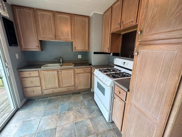 826 N 11th St, Rochelle, IL 61068 - kitchen featuring white gas range oven, a sink, light stone finish floors, and dark countertops