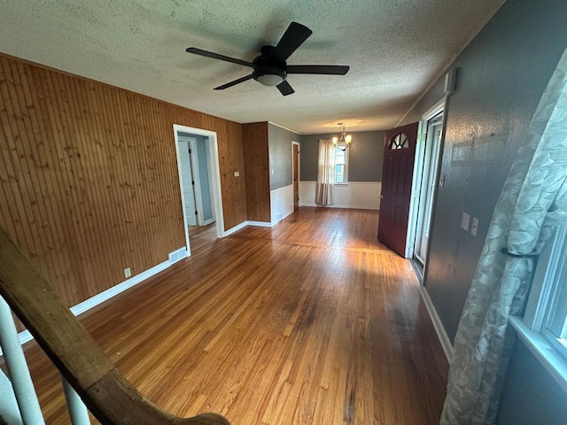 826 N 11th St, Rochelle, IL 61068 - empty room with wood finished floors, a ceiling fan, a chandelier, a textured ceiling, and baseboards