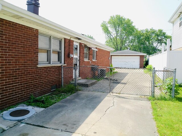 3923 153rd St, Midlothian, IL 60445 - view of side of home featuring a garage, a gate, brick siding, and an outbuilding