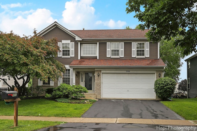 996 Highgate Ln, Grayslake, IL 60030 - traditional-style house featuring asphalt driveway, a garage, a front yard, and brick siding