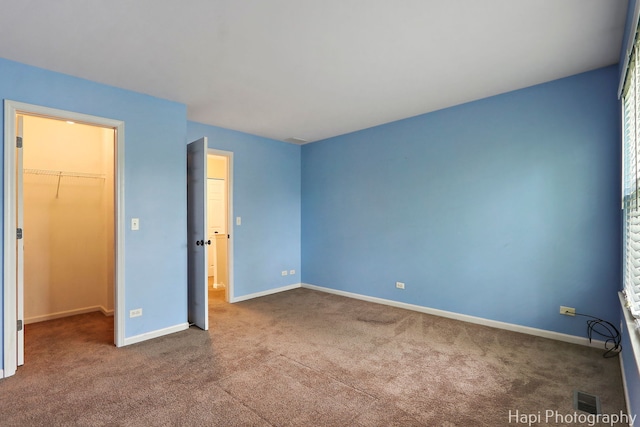 996 Highgate Ln, Grayslake, IL 60030 - unfurnished bedroom with a walk in closet, carpet floors, and a closet