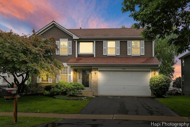 996 Highgate Ln, Grayslake, IL 60030 - traditional-style house featuring an attached garage, asphalt driveway, a lawn, and roof with shingles