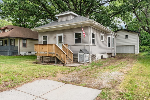 909 Woods Ave, Joliet, IL 60436 - view of front facade with an outbuilding, a front yard, a deck, and a shingled roof