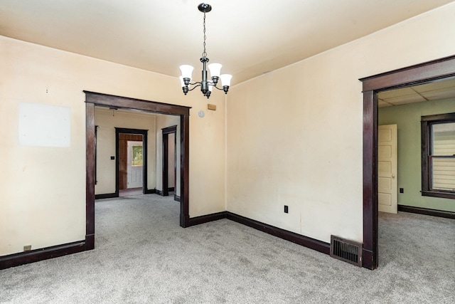 909 Woods Ave, Joliet, IL 60436 - carpeted spare room featuring a chandelier, baseboards, and plenty of natural light
