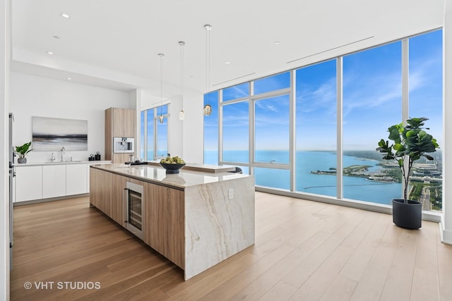 363 E Wacker Dr Unit 7501, Chicago, IL 60601 - kitchen with modern cabinets, wine cooler, a sink, expansive windows, and a large island with sink