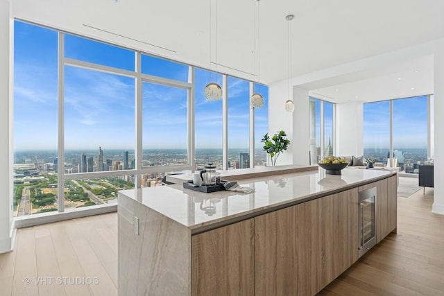 363 E Wacker Dr Unit 7501, Chicago, IL 60601 - kitchen featuring modern cabinets, a wall of windows, healthy amount of natural light, light stone countertops, and light wood-style flooring