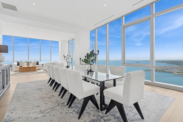 363 E Wacker Dr Unit 7501, Chicago, IL 60601 - dining space featuring a wall of windows, a water view, light wood-style floors, and recessed lighting