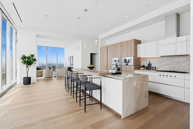363 E Wacker Dr Unit 7501, Chicago, IL 60601 - kitchen featuring modern cabinets, tasteful backsplash, white gas stovetop, light wood-style floors, and recessed lighting