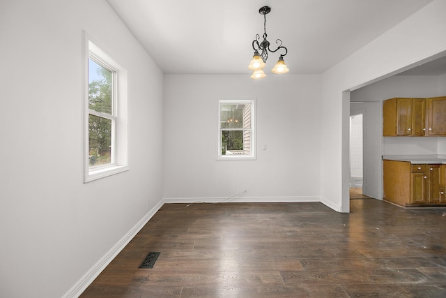 175 N Washington Ave, Kankakee, IL 60901 - unfurnished dining area with healthy amount of natural light, dark wood-style floors, and a chandelier