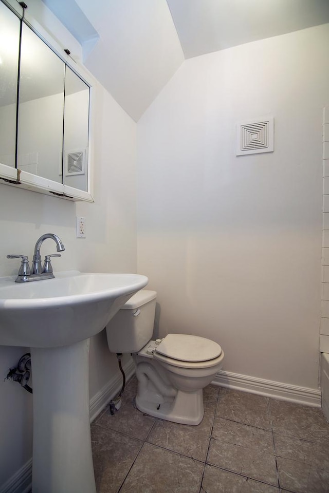 175 N Washington Ave, Kankakee, IL 60901 - bathroom featuring vaulted ceiling, toilet, baseboards, and a sink