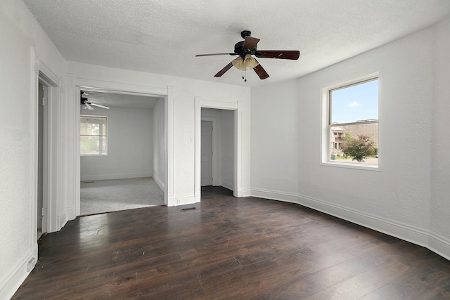 175 N Washington Ave, Kankakee, IL 60901 - unfurnished bedroom with dark wood-type flooring, baseboards, a textured ceiling, and a ceiling fan