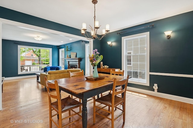 720 Beaver Rd, Glenview, IL 60025 - dining room featuring a chandelier, baseboards, and wood finished floors