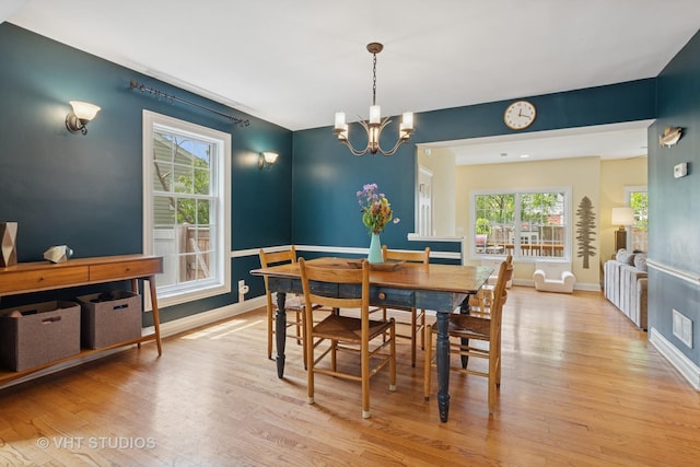 720 Beaver Rd, Glenview, IL 60025 - dining room featuring light wood-type flooring, a chandelier, and baseboards