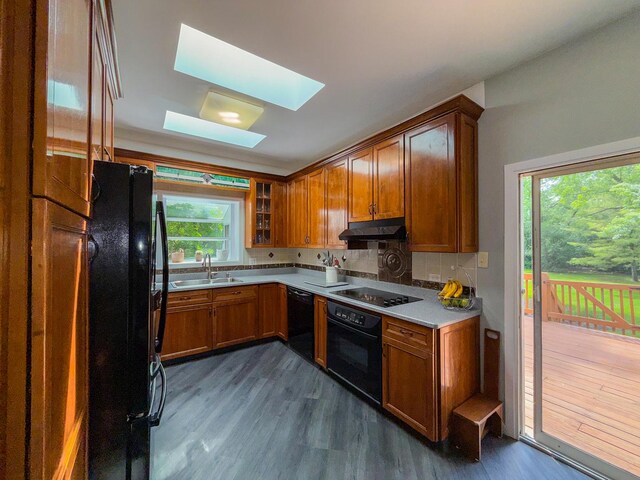 12533 S Iroquois Rd, Palos Park, IL 60464 - kitchen with black appliances, a sink, brown cabinets, dark wood-style floors, and a skylight