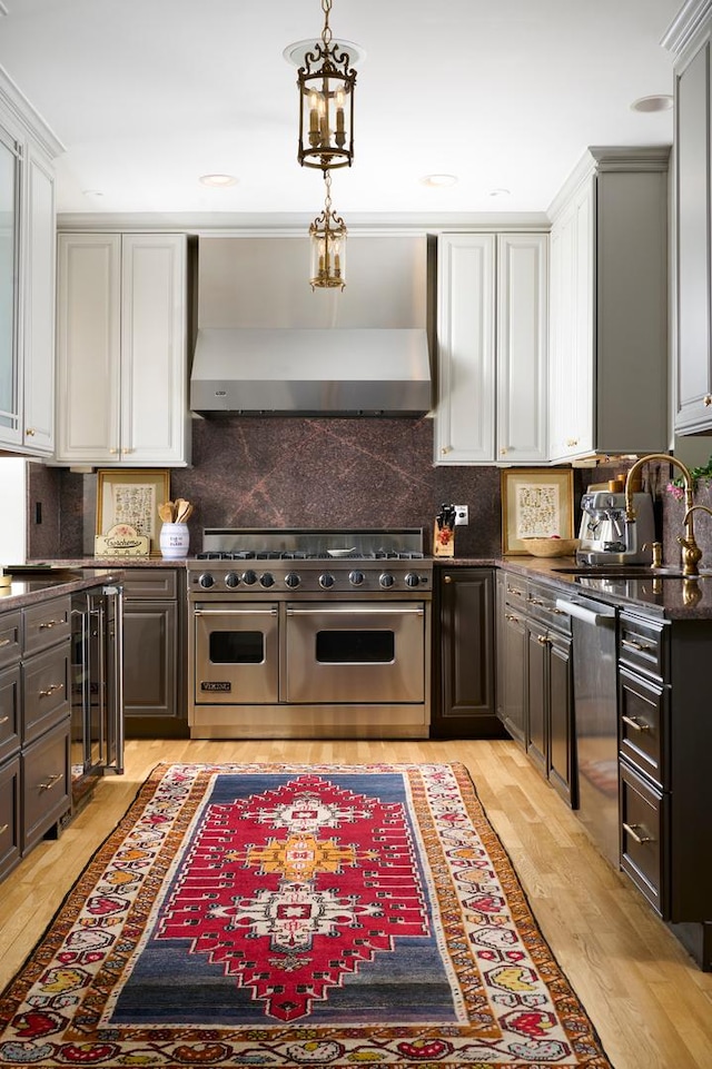 635 W Sheridan Rd Unit 3, Chicago, IL 60613 - kitchen featuring appliances with stainless steel finishes, exhaust hood, beverage cooler, light wood finished floors, and white cabinetry