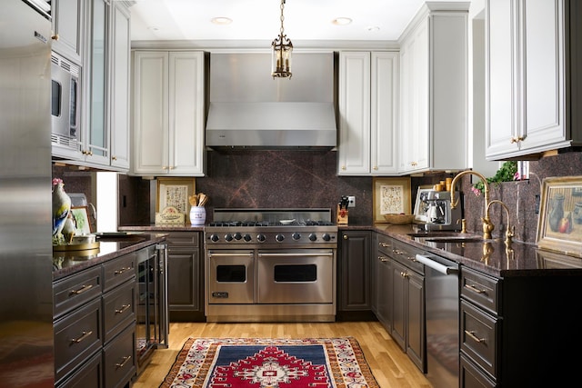 635 W Sheridan Rd Unit 3, Chicago, IL 60613 - kitchen with premium appliances, a sink, white cabinets, light wood-style floors, and dark stone counters