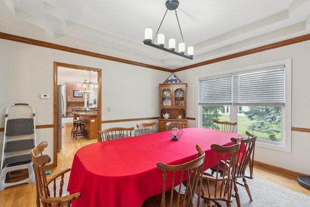 310 Westhaven Cir, Geneva, IL 60134 - dining area featuring a chandelier, a tray ceiling, light wood-type flooring, ornamental molding, and baseboards