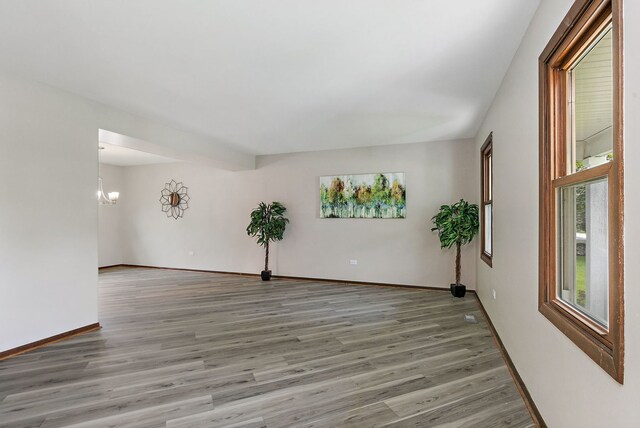 36 Shore Dr, Schaumburg, IL 60193 - unfurnished room with light wood-style floors, a chandelier, healthy amount of natural light, and baseboards