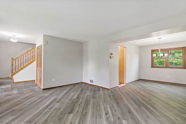 36 Shore Dr, Schaumburg, IL 60193 - spare room with wood finished floors, baseboards, stairs, and a chandelier