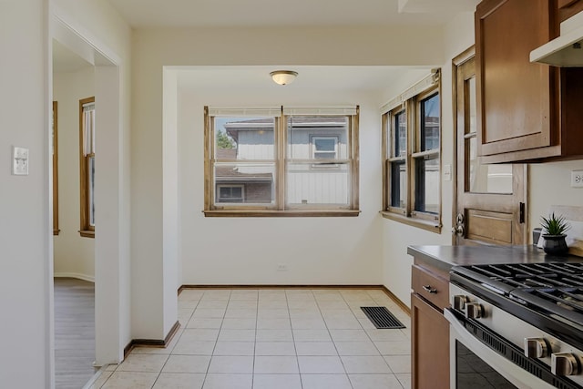 1970 E 170th St, South Holland, IL 60473 - kitchen with stainless steel range with gas cooktop, under cabinet range hood, baseboards, and light tile patterned floors